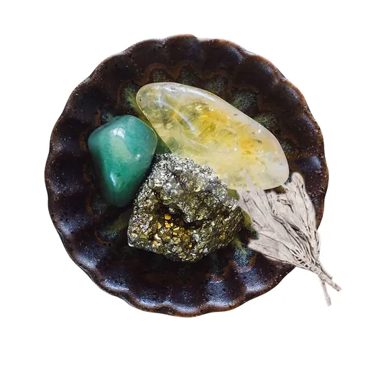 A small ceramic dish holding a curated collection of polished and raw crystals